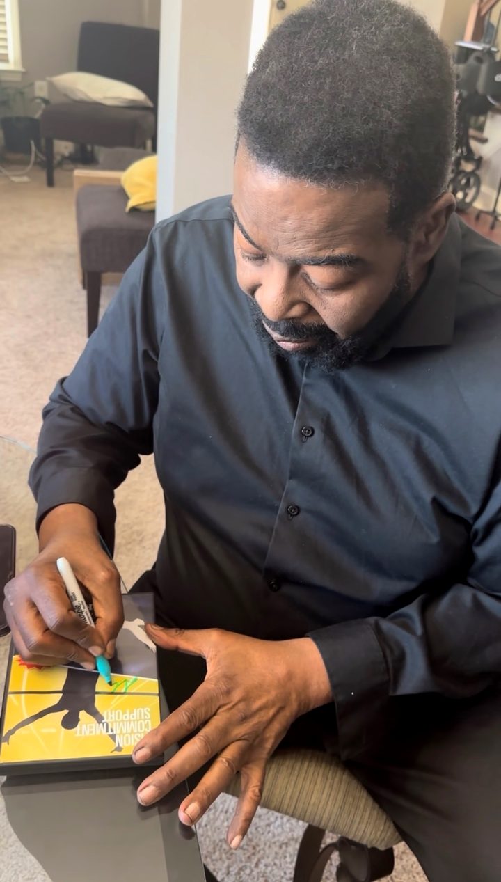 Les Brown signing a book.